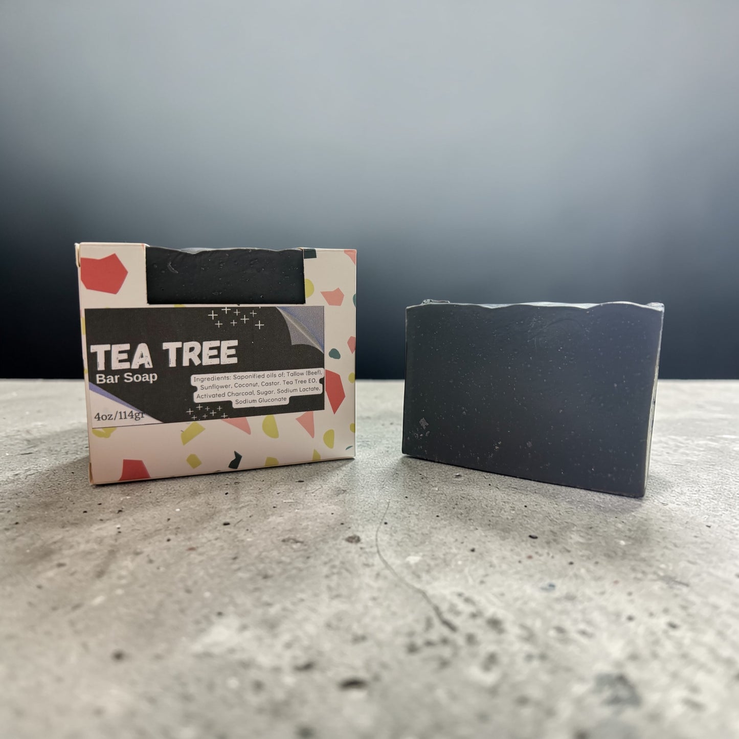 Tea tree bar soap with packaging on a gray surface