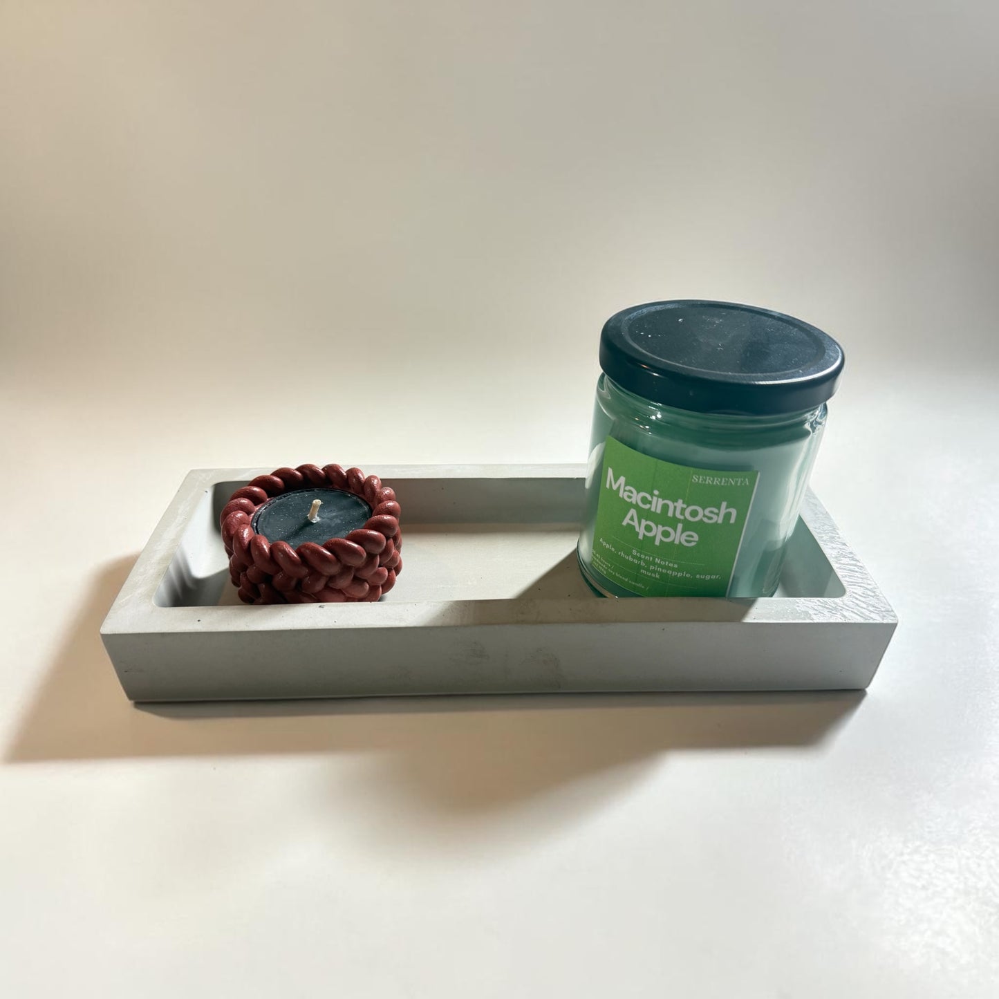 A rectangular concrete tray with two candles on it