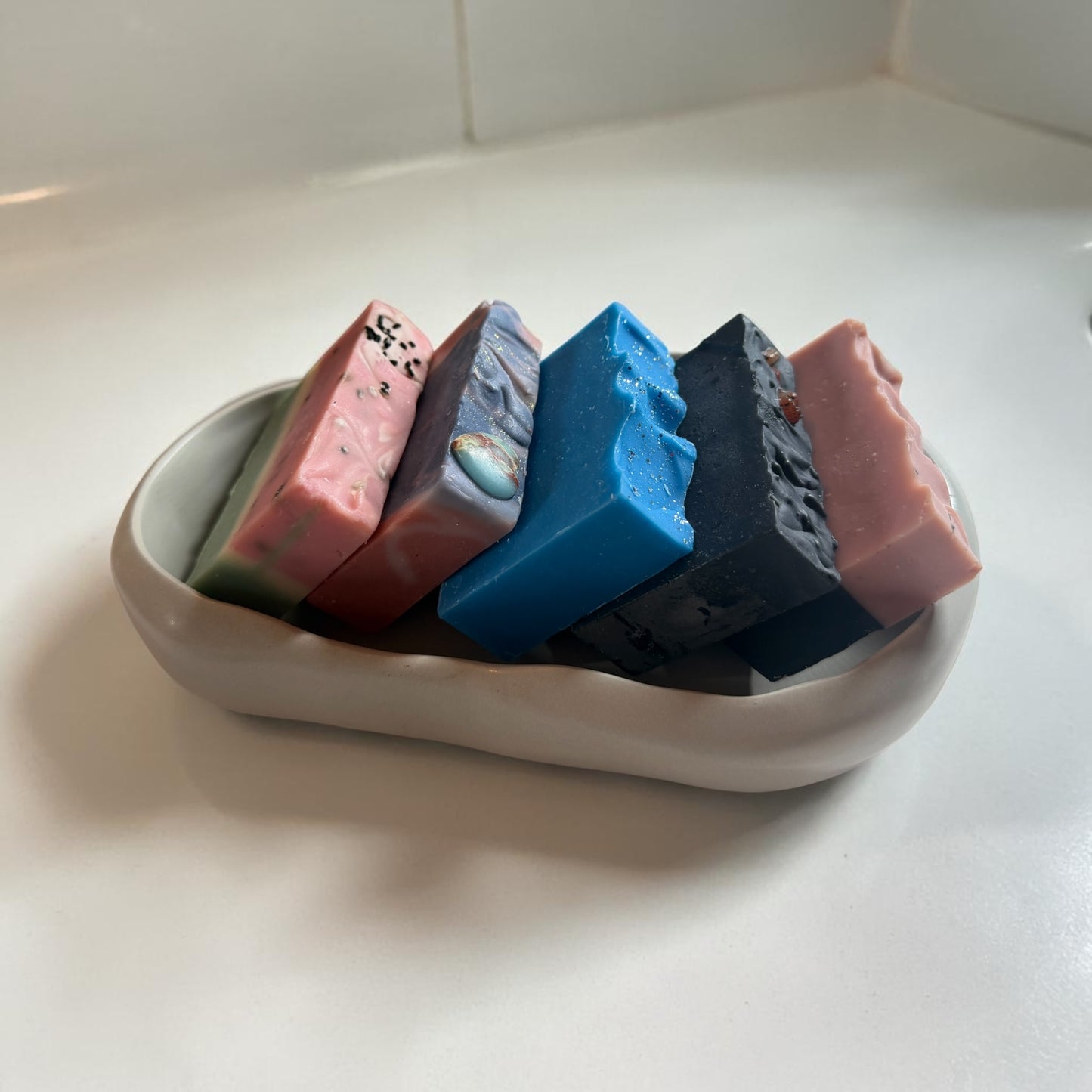 A grey cement tray with soaps in it for display