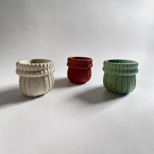 Three concrete toohtbrush holders, beige, red and green