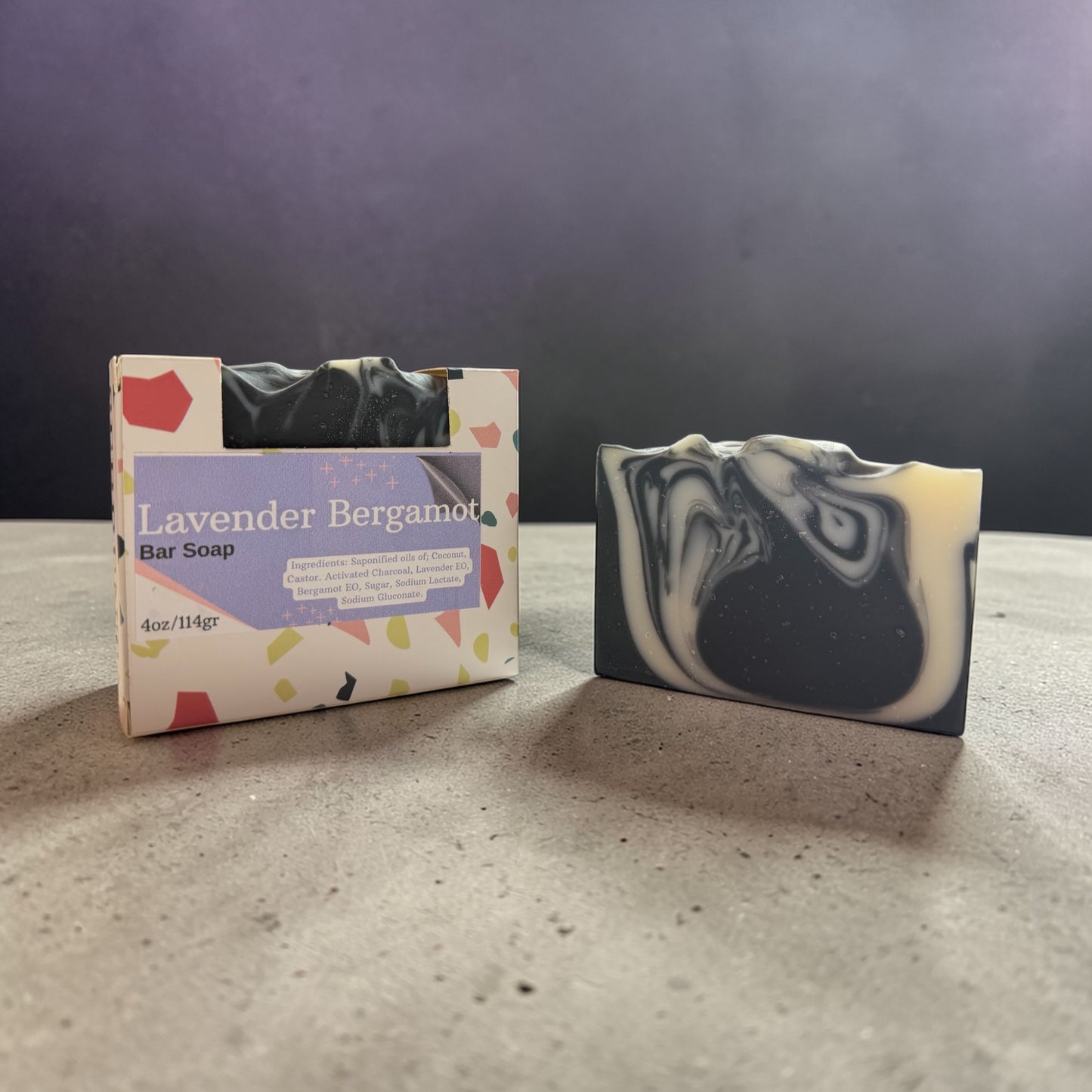 Bar of soap with a colorful label on a gray surface against a dark background