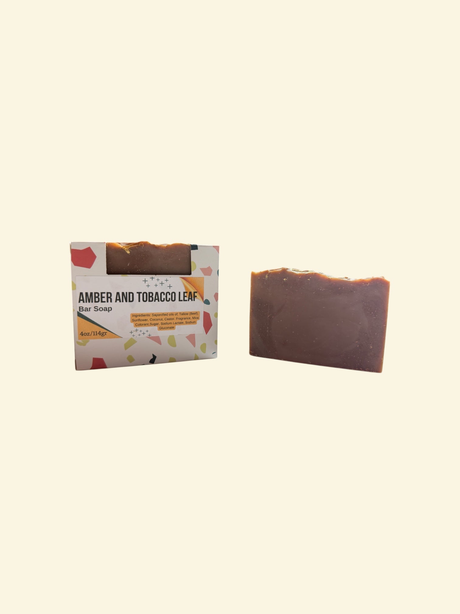 Bar of soap with packaging labeled 'Amber and Tobacco Leaf' on a beige background