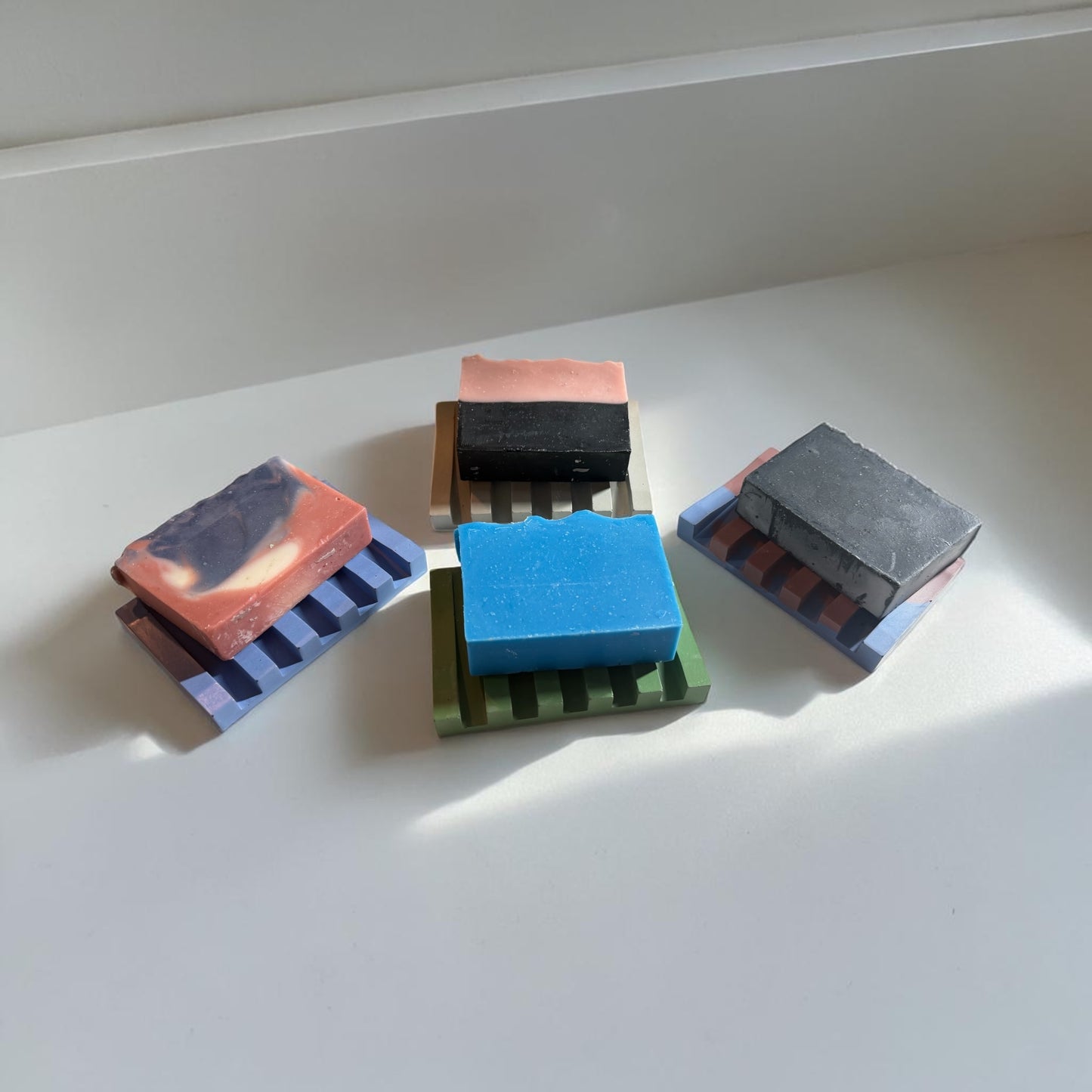 Four rectangular soap dishes with soaps on them