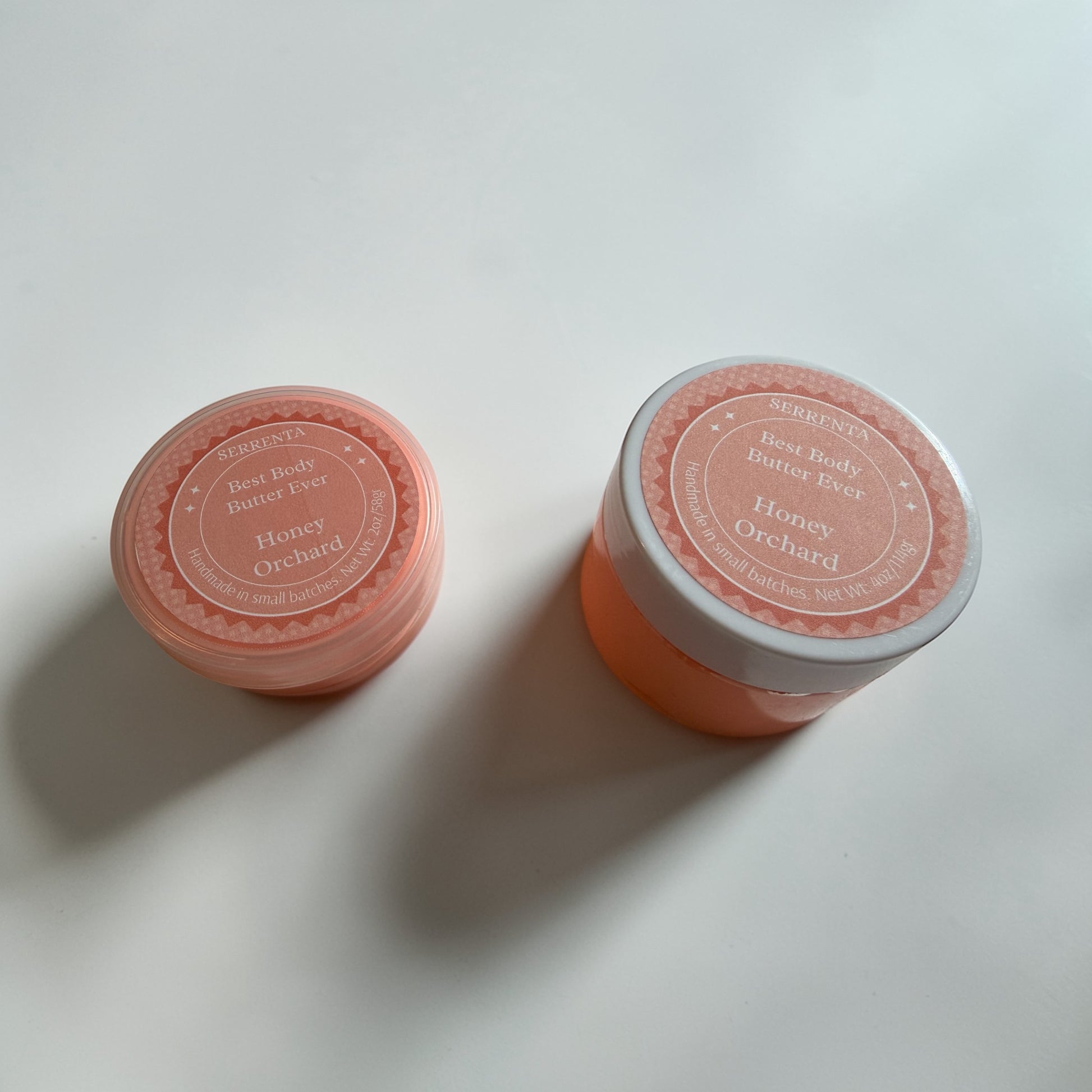 Two pink jars labeled 'Honey Orchard' on a light gray background